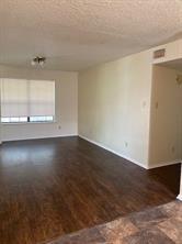 2507 Stella Street, Unit C Denton, TX 76201 - Photo 2 of 5 an empty room with wooden floor and windows