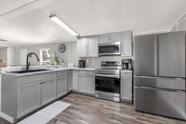 a kitchen with kitchen island granite countertop a refrigerator and a sink