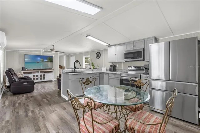 a kitchen with a refrigerator a stove a dining table and chairs