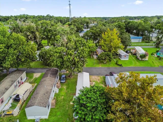 an aerial view of a house with a yard basket ball court and outdoor seating