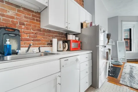 a kitchen with stainless steel appliances white cabinets and a refrigerator