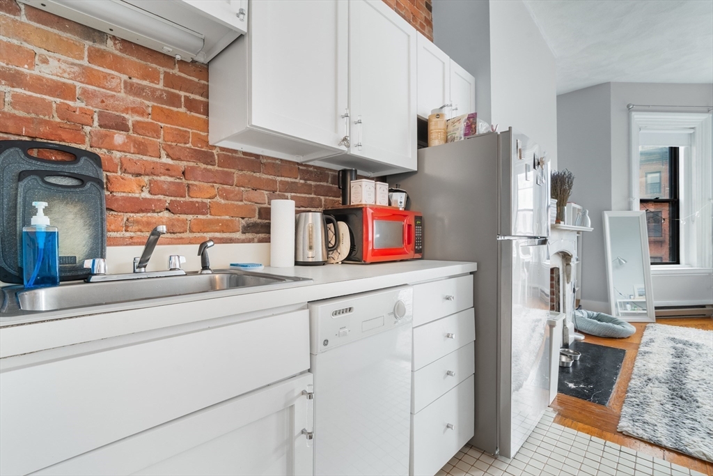 389 Beacon Street, Unit 8 Boston, MA 02116 - Photo 5 of 9 a kitchen with stainless steel appliances white cabinets and a refrigerator