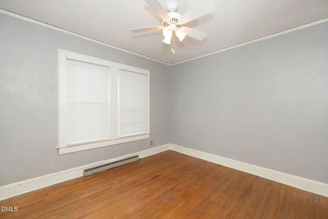 an empty room with a window and a ceiling fan