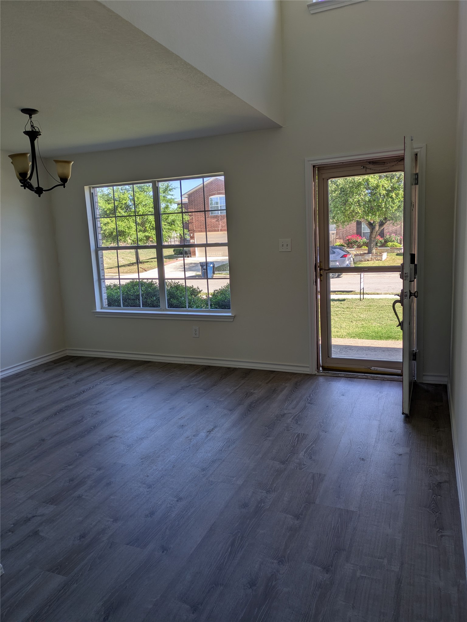 209 Phillips Street Hutto, TX 78634 - Photo 4 of 11 an empty room with wooden floor and windows