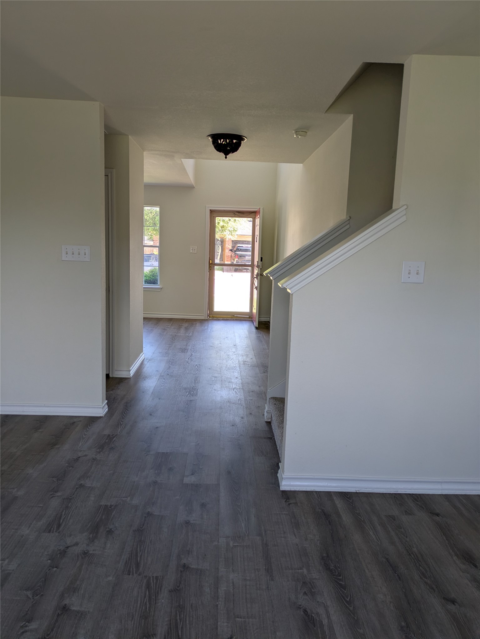 209 Phillips Street Hutto, TX 78634 - Photo 5 of 11 an empty room with wooden floor and windows