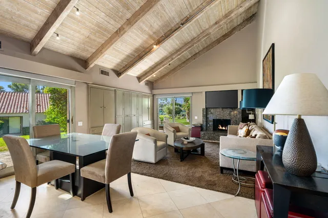 a living room with furniture a table and a large window