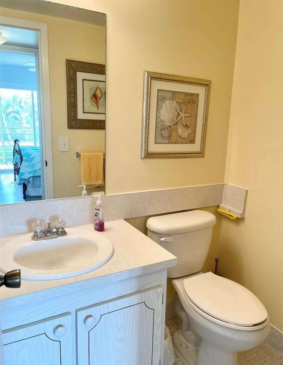 84 Brighton B, Unit 84 Boca Raton, FL 33434 - Photo 11 of 28 a bathroom with a toilet a sink and mirror