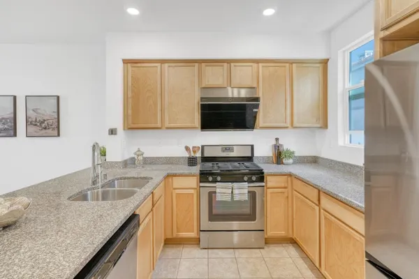 a kitchen with a sink stove top oven and refrigerator