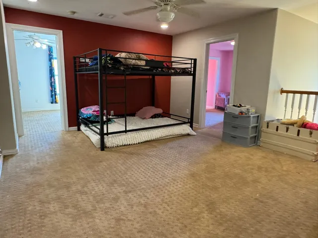 a bedroom with furniture and a lamp on dresser
