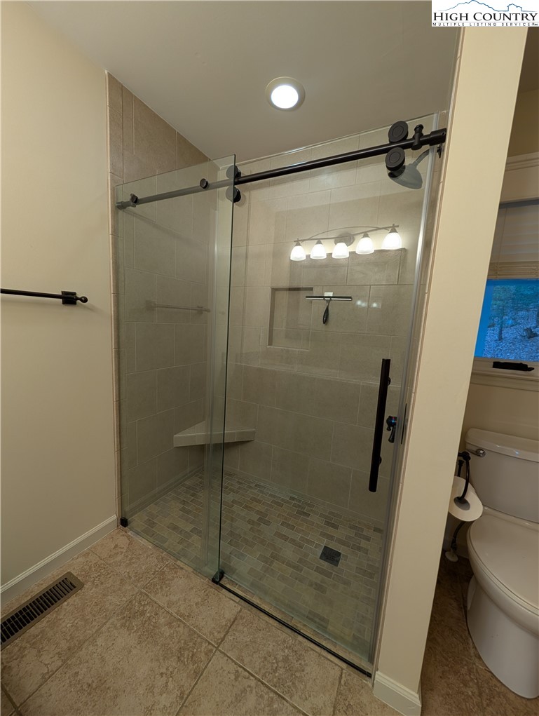57 Village Road Glade Valley, NC 28627 - Photo 13 of 47 a bathroom with a glass door shower and toilet