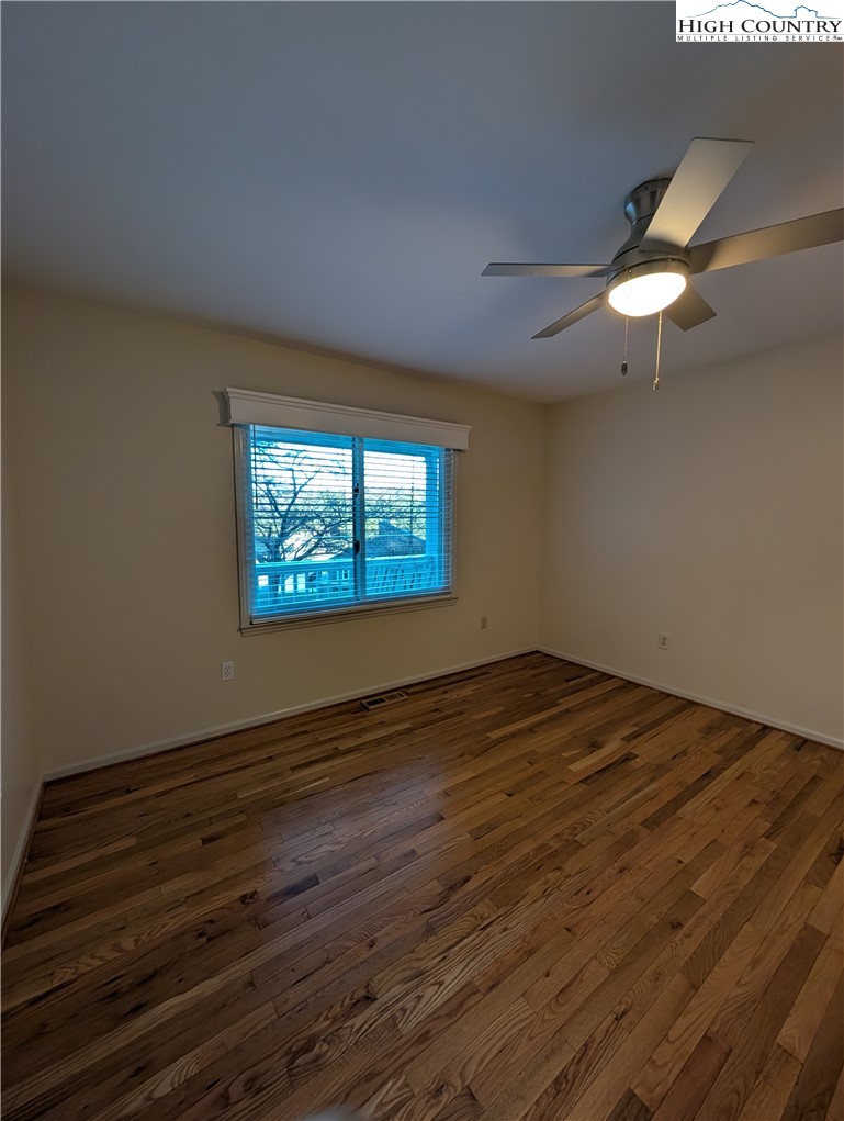 57 Village Road Glade Valley, NC 28627 - Photo 15 of 47 an empty room with wooden floor fan and windows