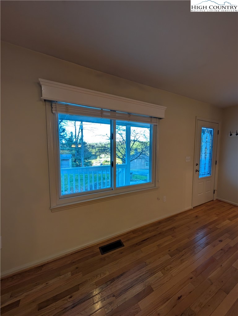 57 Village Road Glade Valley, NC 28627 - Photo 19 of 47 a view of an empty room with wooden floor and a window