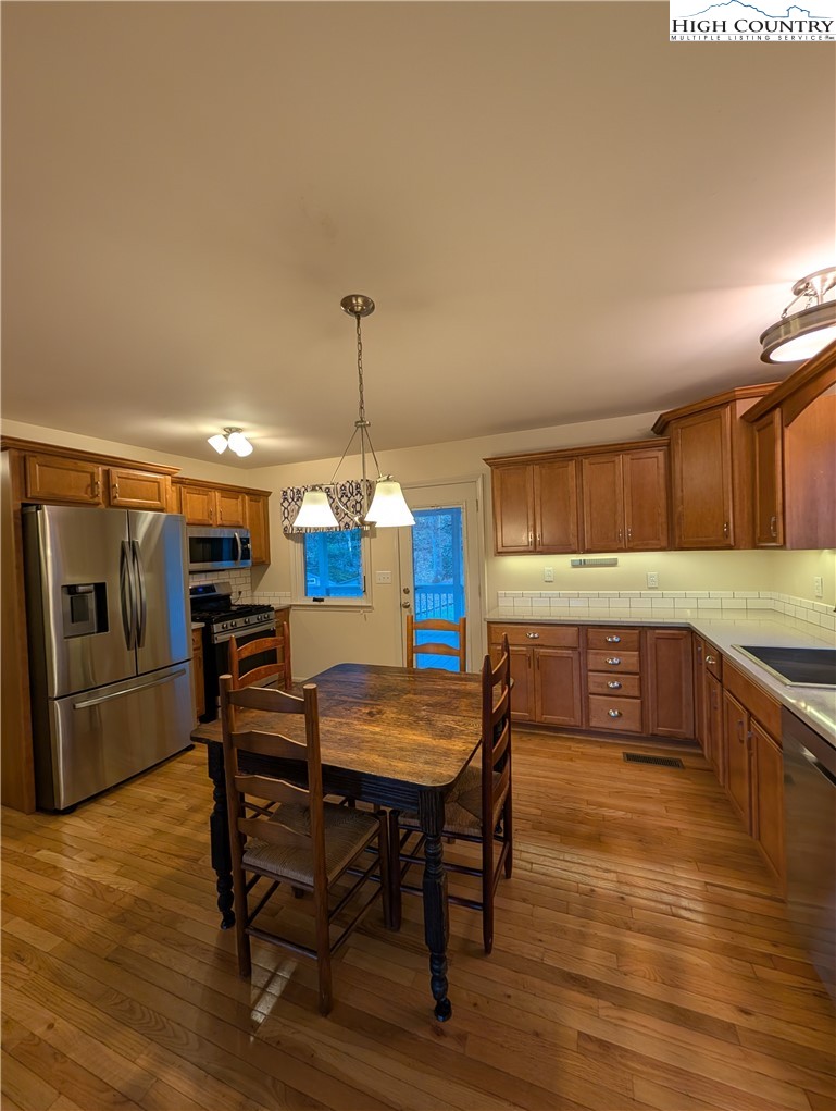57 Village Road Glade Valley, NC 28627 - Photo 8 of 47 a view of a dining room with furniture wooden floor and chandelier