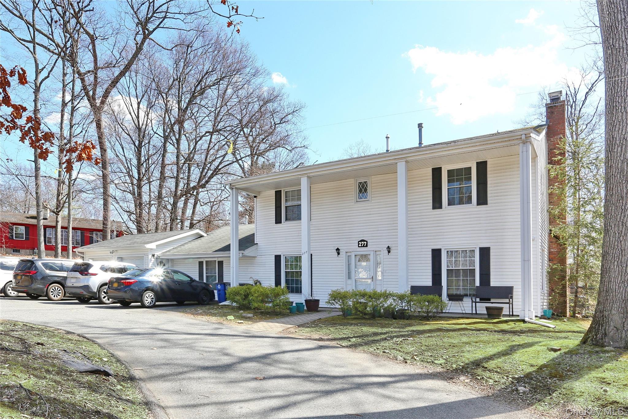 a view of a white house with a large windows next to a road