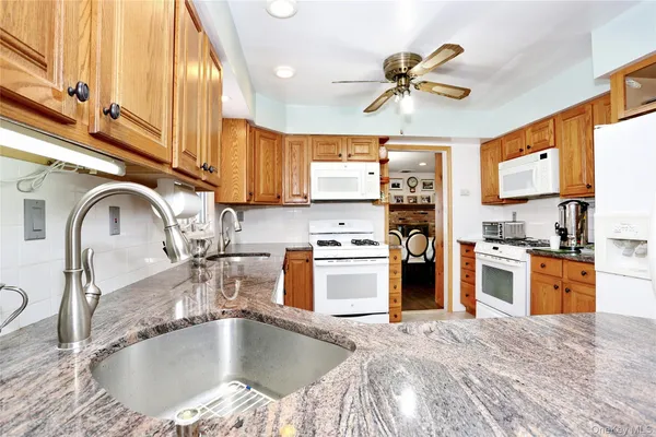 a kitchen with stainless steel appliances granite countertop a sink window and a refrigerator