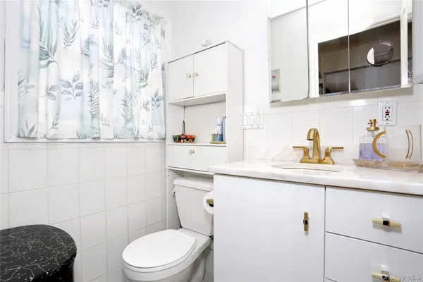 a bathroom with a sink a toilet and mirror