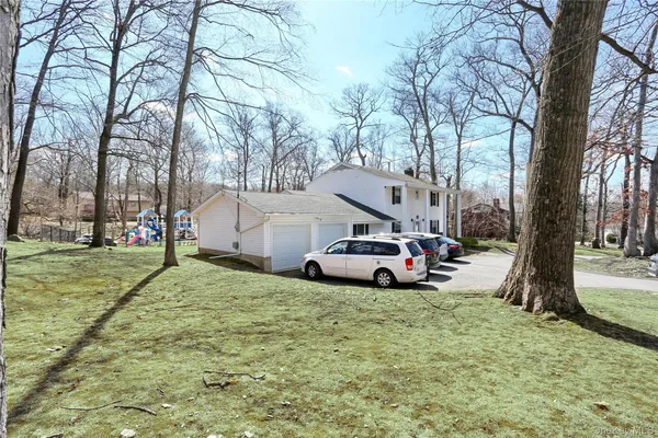a view of a yard with car parked on the road
