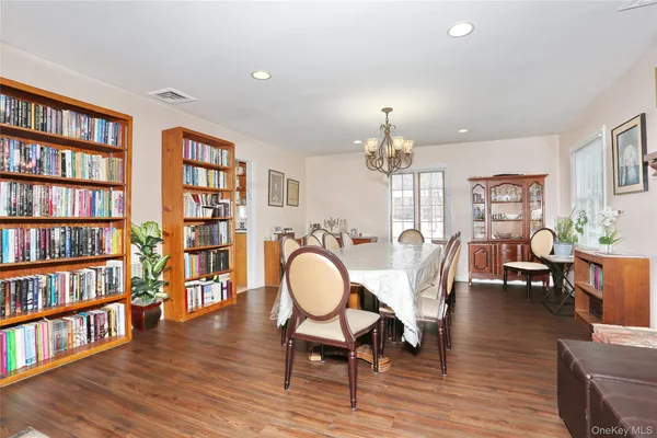 a view of a livingroom with furniture bookshelf and wooden floor