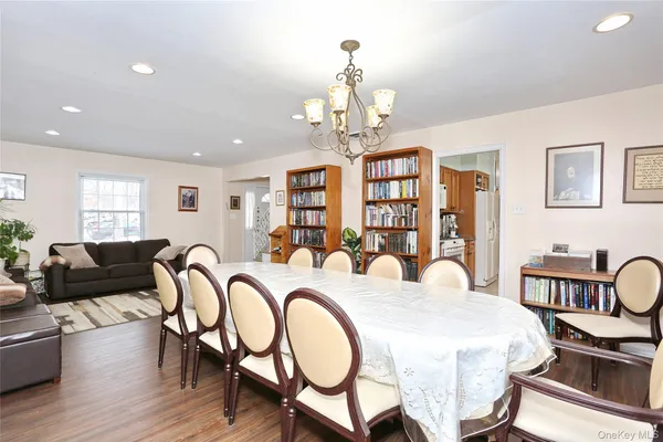 a very nice looking dining room with furniture a chandelier and wooden floor