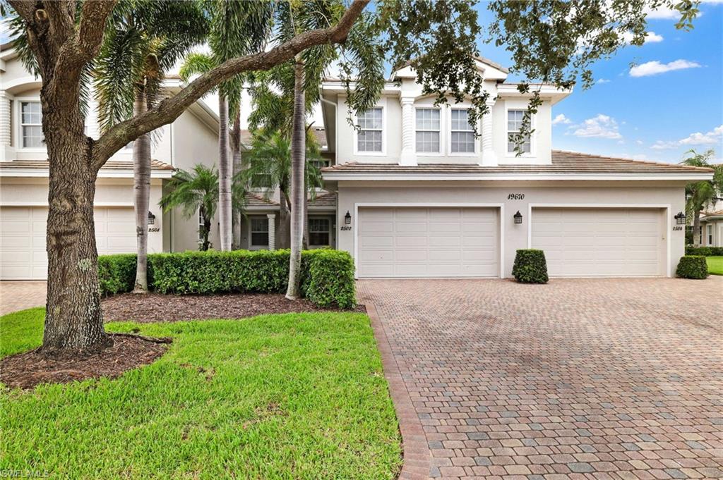 19670 Marino Lake Circle, Unit 2502 Miromar Lakes, FL 33913 - Photo 20 of 40 a front view of a house with a yard and garage