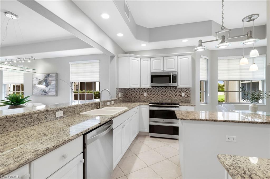 19670 Marino Lake Circle, Unit 2502 Miromar Lakes, FL 33913 - Photo 3 of 40 a kitchen with granite countertop a sink stainless steel appliances and counter space
