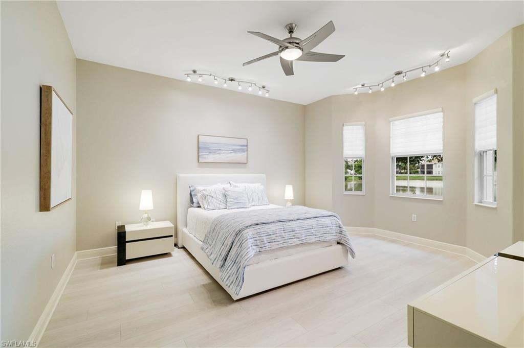 19670 Marino Lake Circle, Unit 2502 Miromar Lakes, FL 33913 - Photo 7 of 40 a spacious bedroom with a bed painting on wall and windows