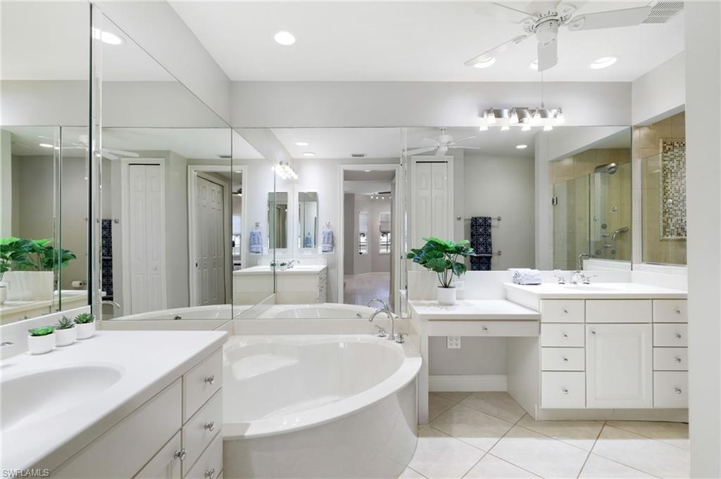 19670 Marino Lake Circle, Unit 2502 Miromar Lakes, FL 33913 - Photo 9 of 40 a large bathroom with a sink a large mirror and a shower