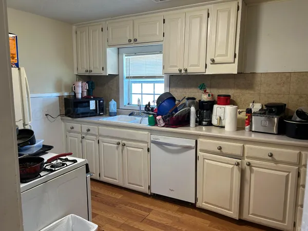 a kitchen with white cabinets and white appliances
