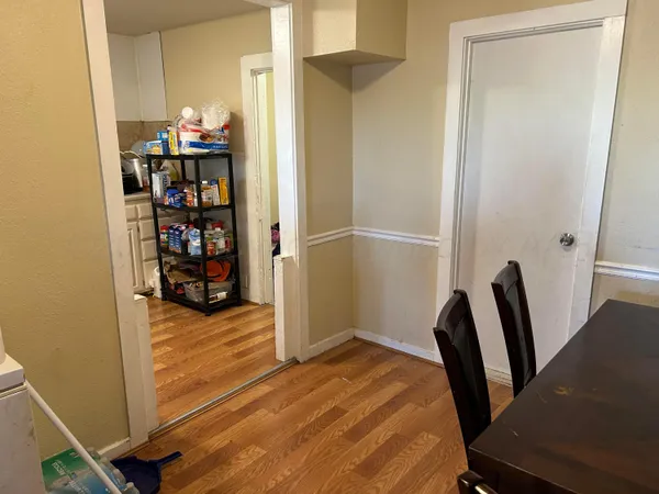 a bedroom with a bed and a bookshelf with wooden floor