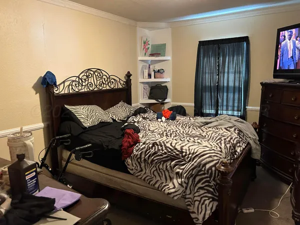 a bed sitting in a bedroom next to a window
