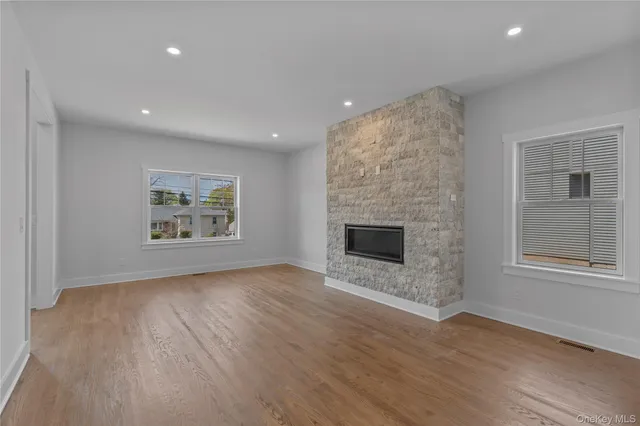 an empty room with windows and fireplace