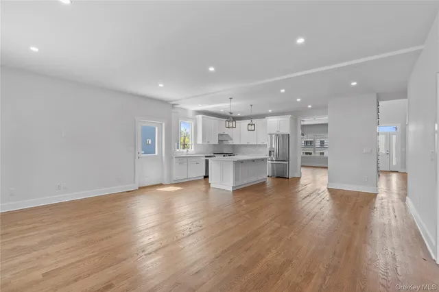 a view of kitchen with kitchen island wooden floor center island and stainless steel appliances