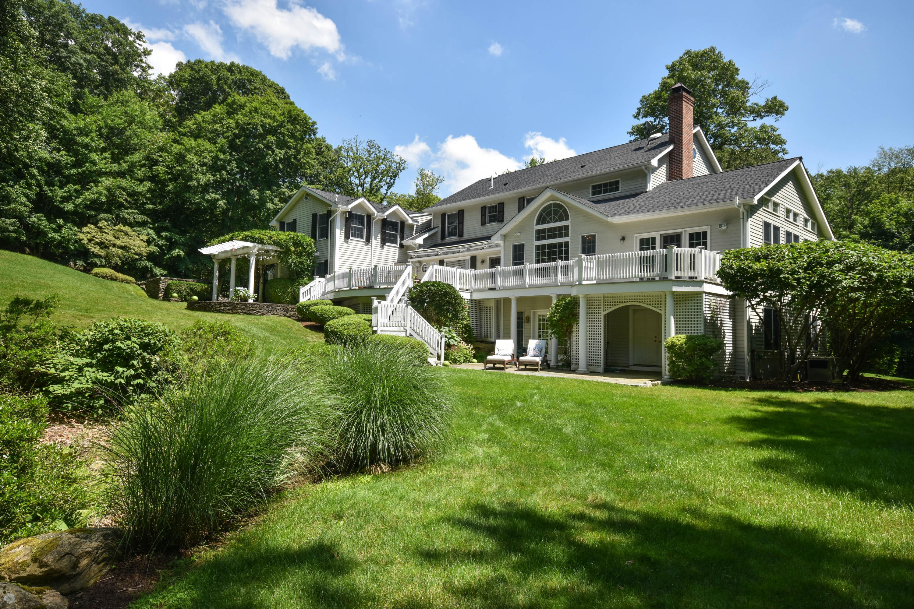 104 Jonathan Road New Canaan, CT 06840 - Photo 19 of 25 a front view of a house with a yard and garage