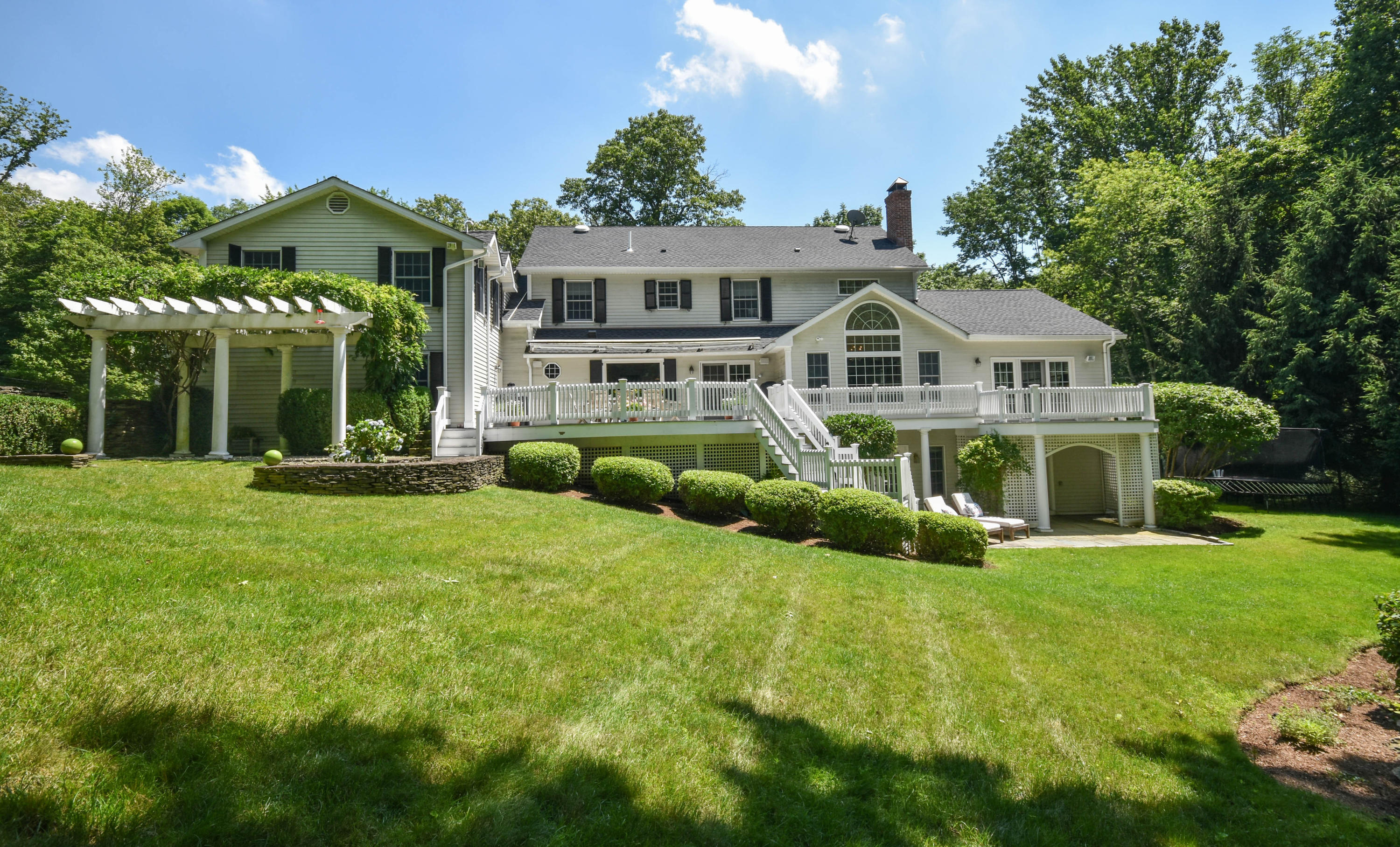 104 Jonathan Road New Canaan, CT 06840 - Photo 20 of 25 a front view of a house with a yard table and chairs