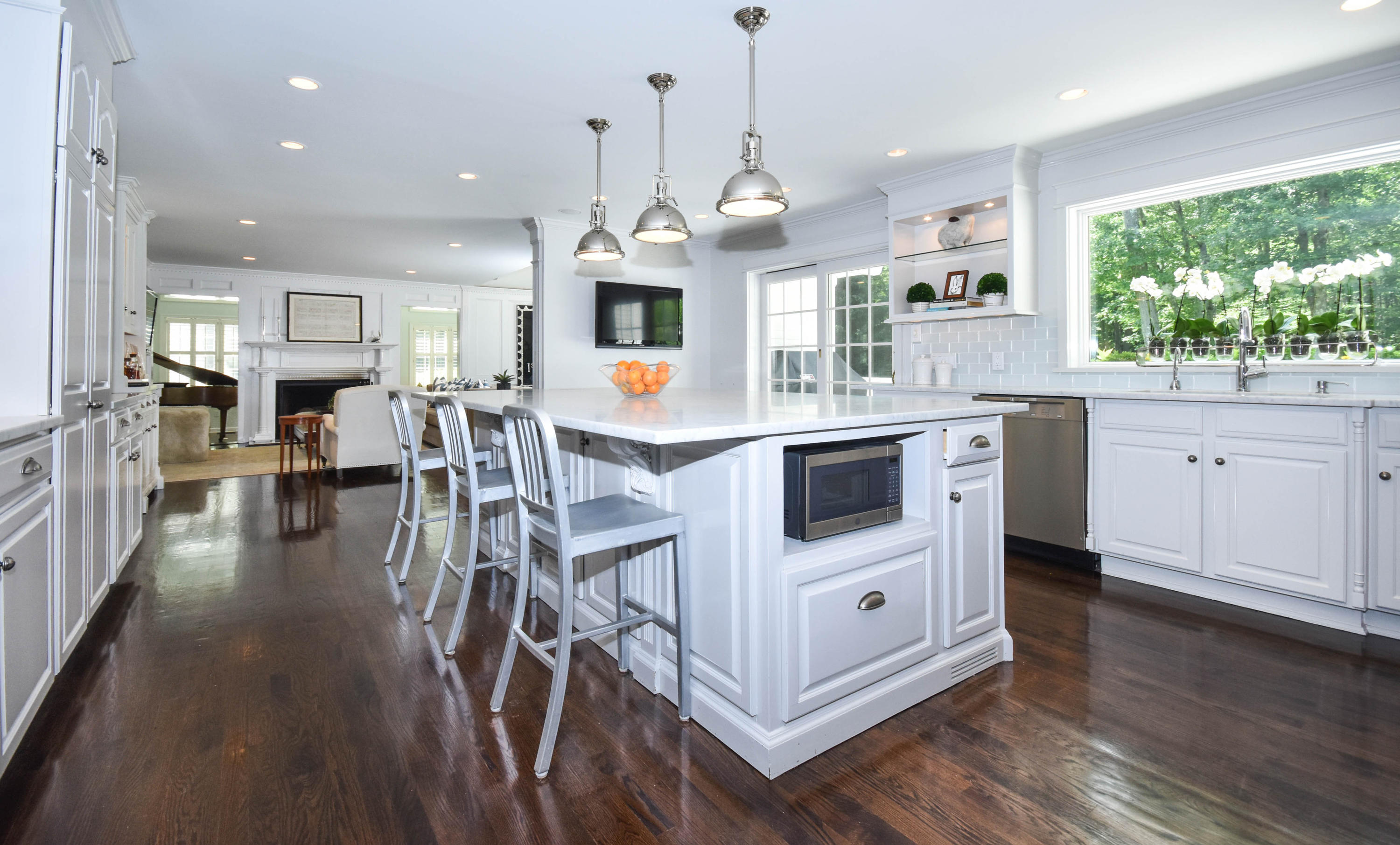 104 Jonathan Road New Canaan, CT 06840 - Photo 8 of 25 a kitchen with stainless steel appliances kitchen island a white stove top oven a sink a dining table and chairs with wooden floor