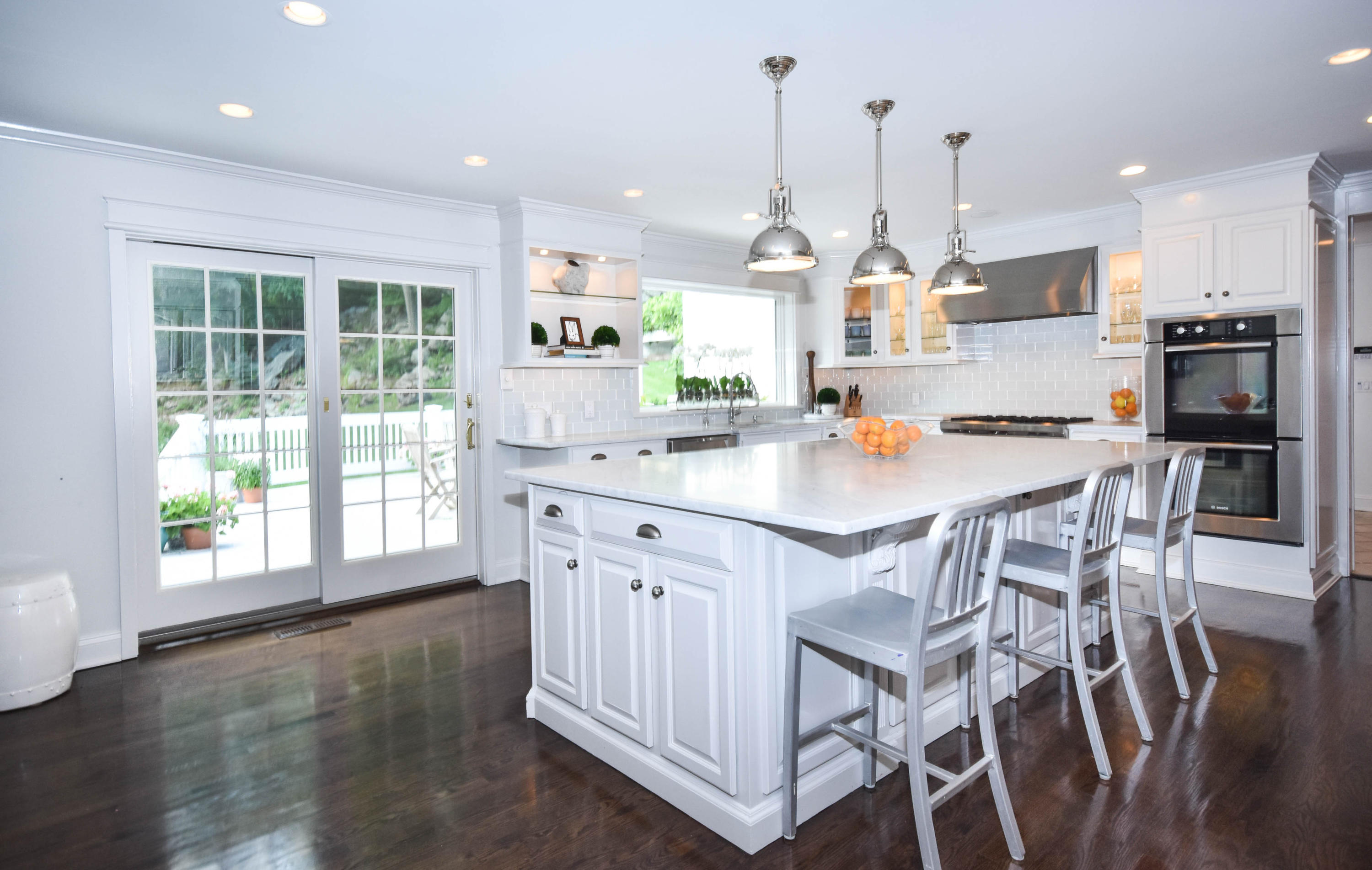 104 Jonathan Road New Canaan, CT 06840 - Photo 9 of 25 a kitchen with stainless steel appliances kitchen island granite countertop a table chairs and a wooden floor