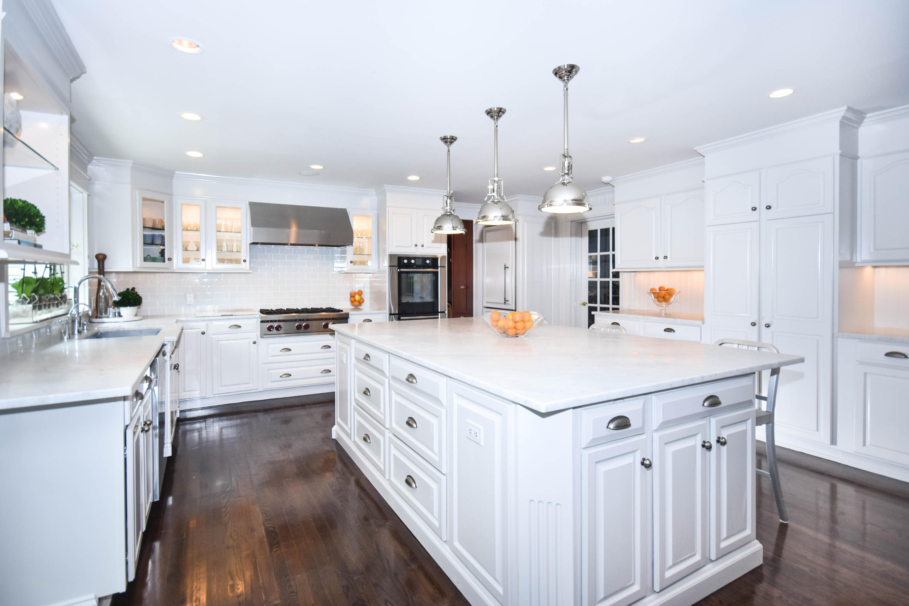 104 Jonathan Road New Canaan, CT 06840 - Photo 10 of 25 a kitchen with kitchen island granite countertop a sink a stove a refrigerator and white cabinets with wooden floor