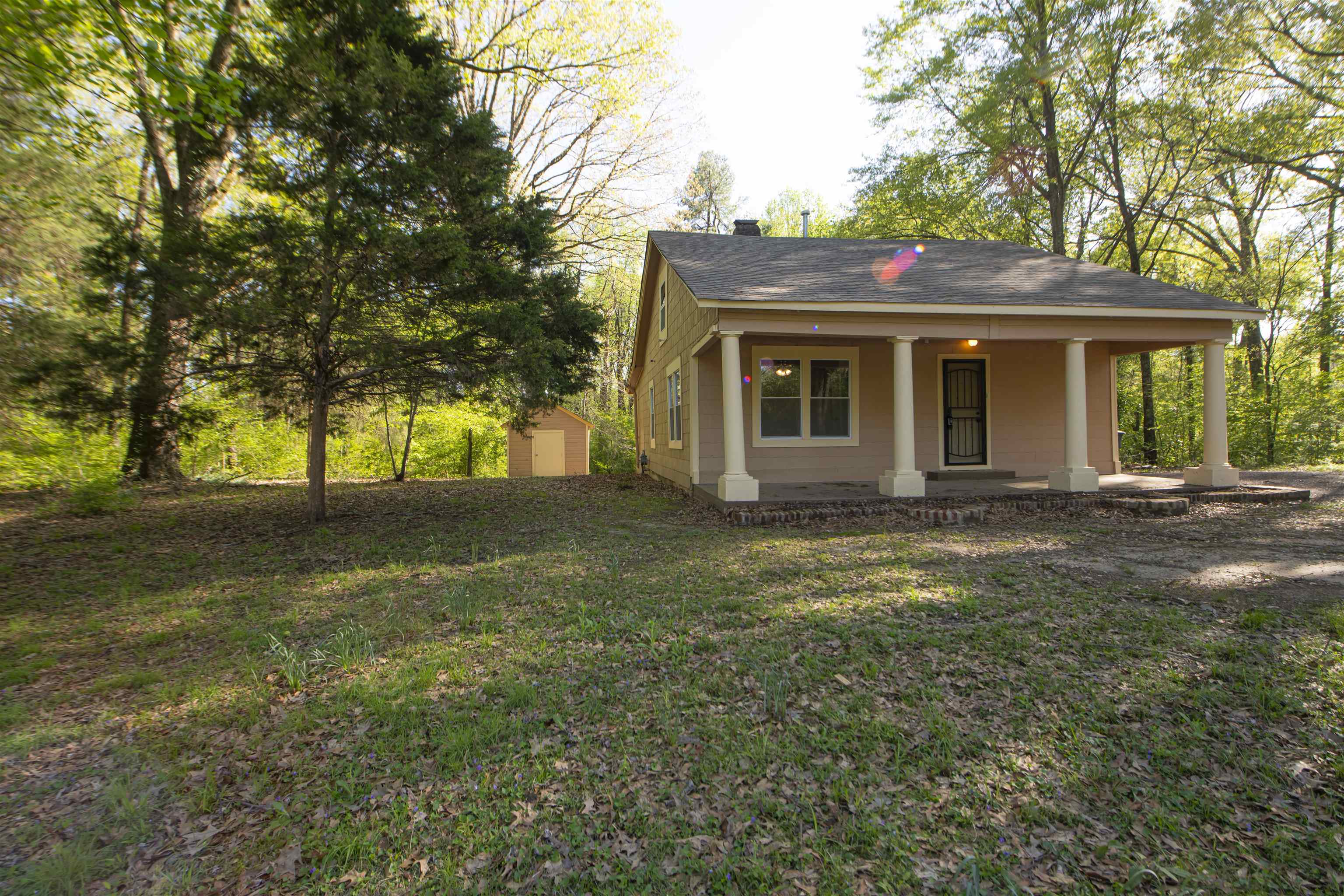 899 Craft Road Memphis, TN 38116 - Photo 13 of 13 Exterior space with a shed, a porch, a front lawn, and an outbuilding
