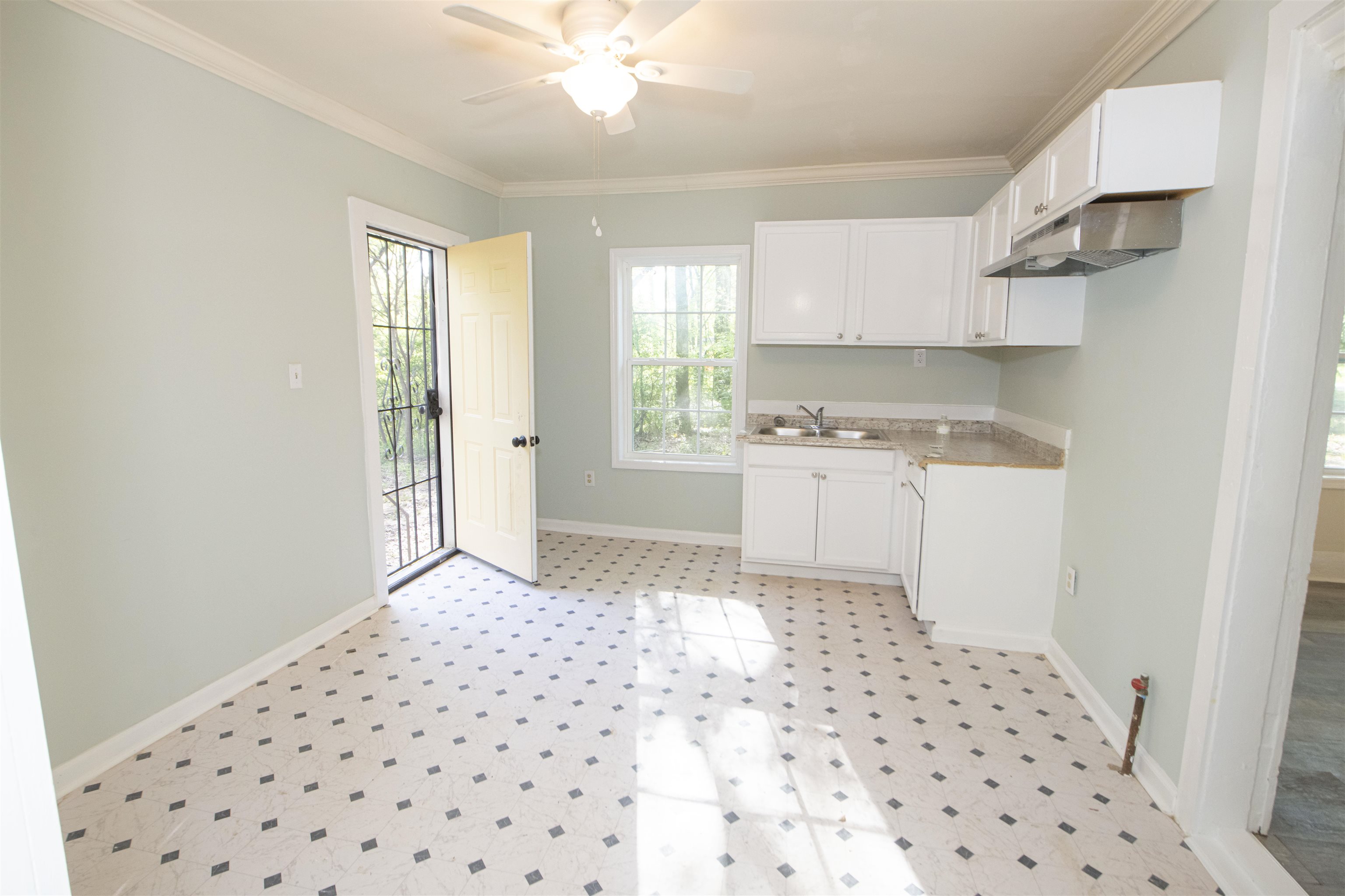 899 Craft Road Memphis, TN 38116 - Photo 8 of 13 Kitchen featuring baseboards, light floors, white cabinetry, ceiling fan, and a sink