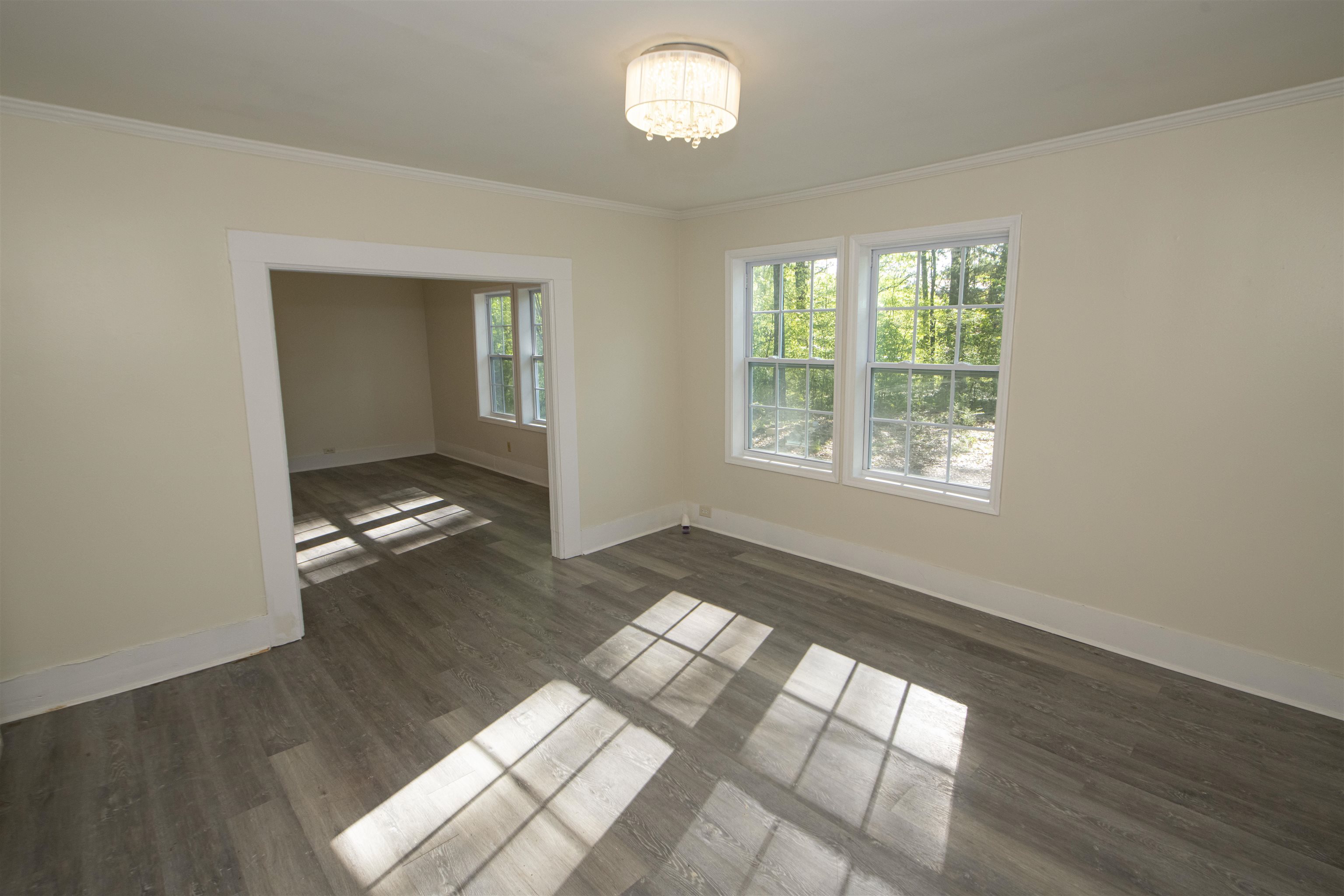 899 Craft Road Memphis, TN 38116 - Photo 9 of 13 Empty room featuring baseboards, an inviting chandelier, crown molding, and wood finished floors