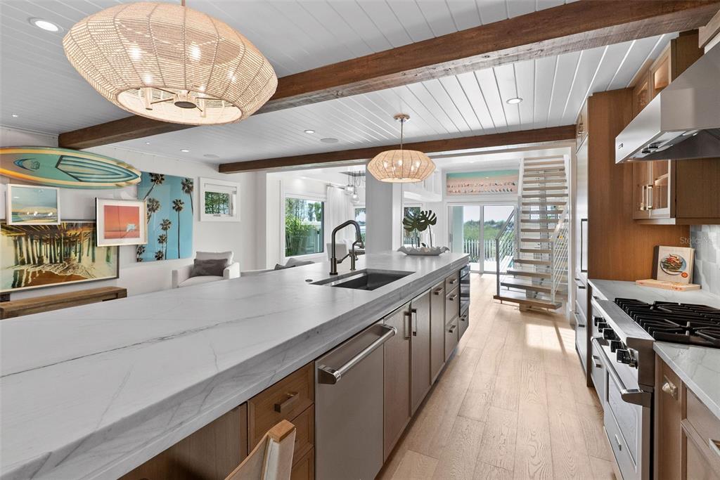 2807 Sunset Way St. Pete Beach, FL 33706 - Photo 11 of 49 a kitchen with stainless steel appliances a counter space a large window and cabinets