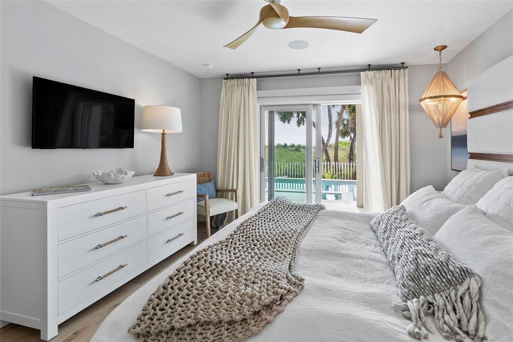 2807 Sunset Way St. Pete Beach, FL 33706 - Photo 19 of 49 a bedroom with a large bed and a flat tv screen on dresser