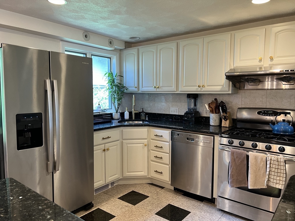 11 Garrison Road, Unit 1 Arlington, MA 02474 - Photo 5 of 42 a kitchen with white cabinets and white appliances
