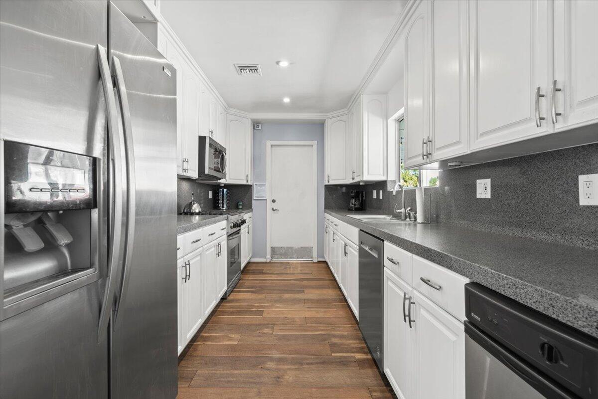 2236 North Victoria Road Palm Springs, CA 92262 - Photo 8 of 40 a large kitchen with stainless steel appliances granite countertop a refrigerator a sink a stove and white cabinets