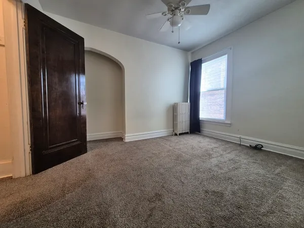 an empty room with fan and windows