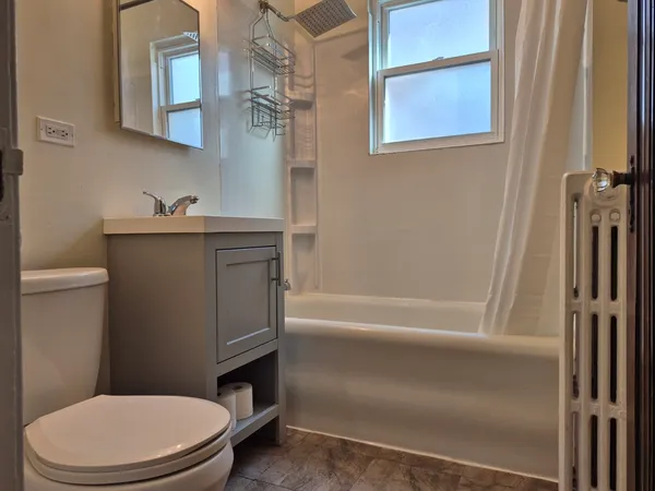 a bathroom with a granite countertop toilet sink and mirror