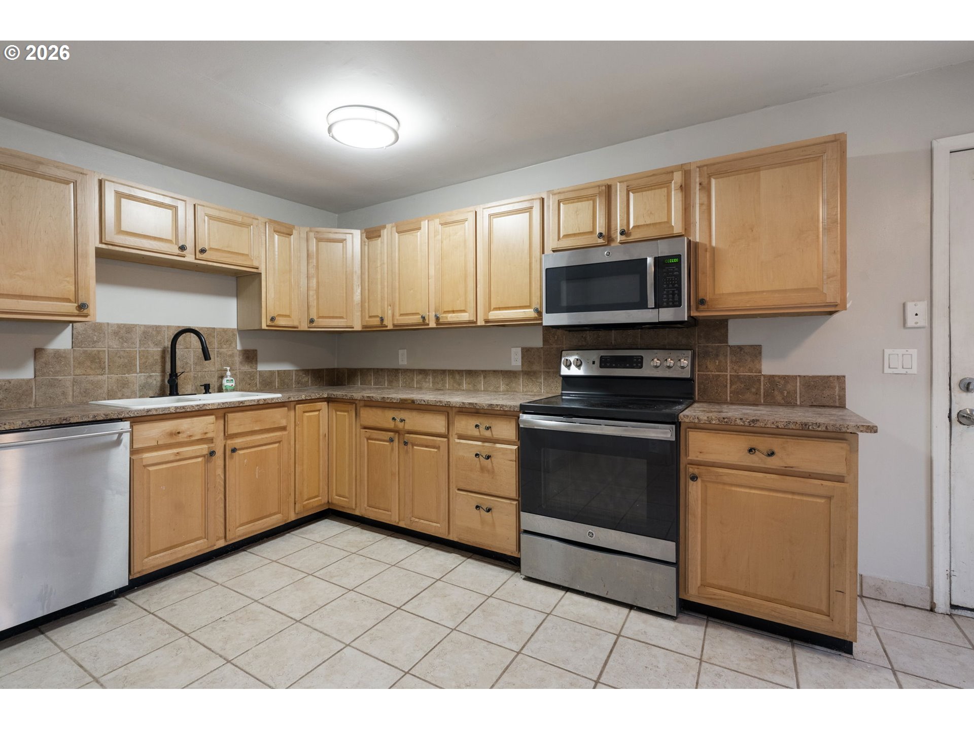 25106 Northeast 25th Street Camas, WA 98607 - Photo 11 of 47 a kitchen with stainless steel appliances granite countertop a stove a sink and a microwave