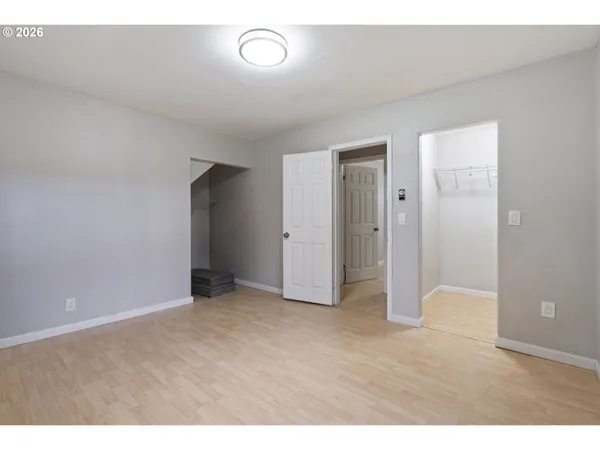 a view of an empty room with closet and entryway