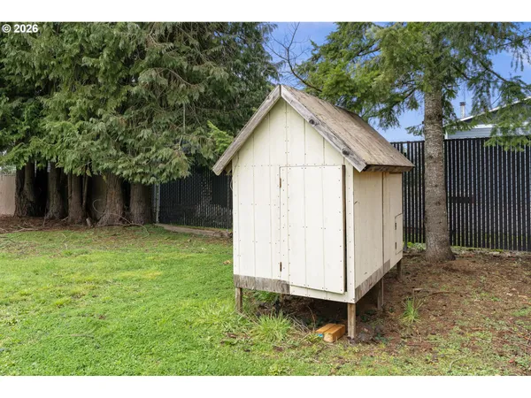 a view of a backyard with barn and wooden fence