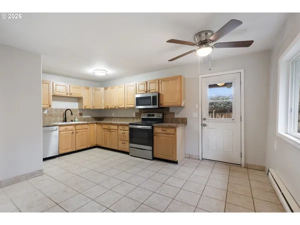 a kitchen with a sink a counter top space cabinets and stainless steel appliances